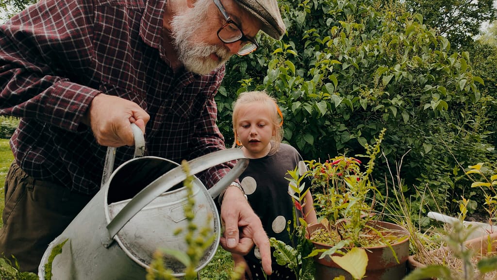 A grandfather and his granddaughter water a garden together, the long view behind planned giving in Indiana.