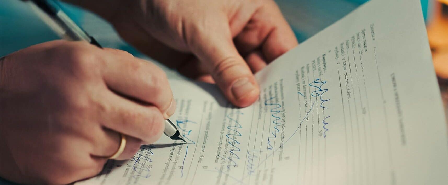 Person signing a legal document at a desk — estate planning signing meeting in Indiana
