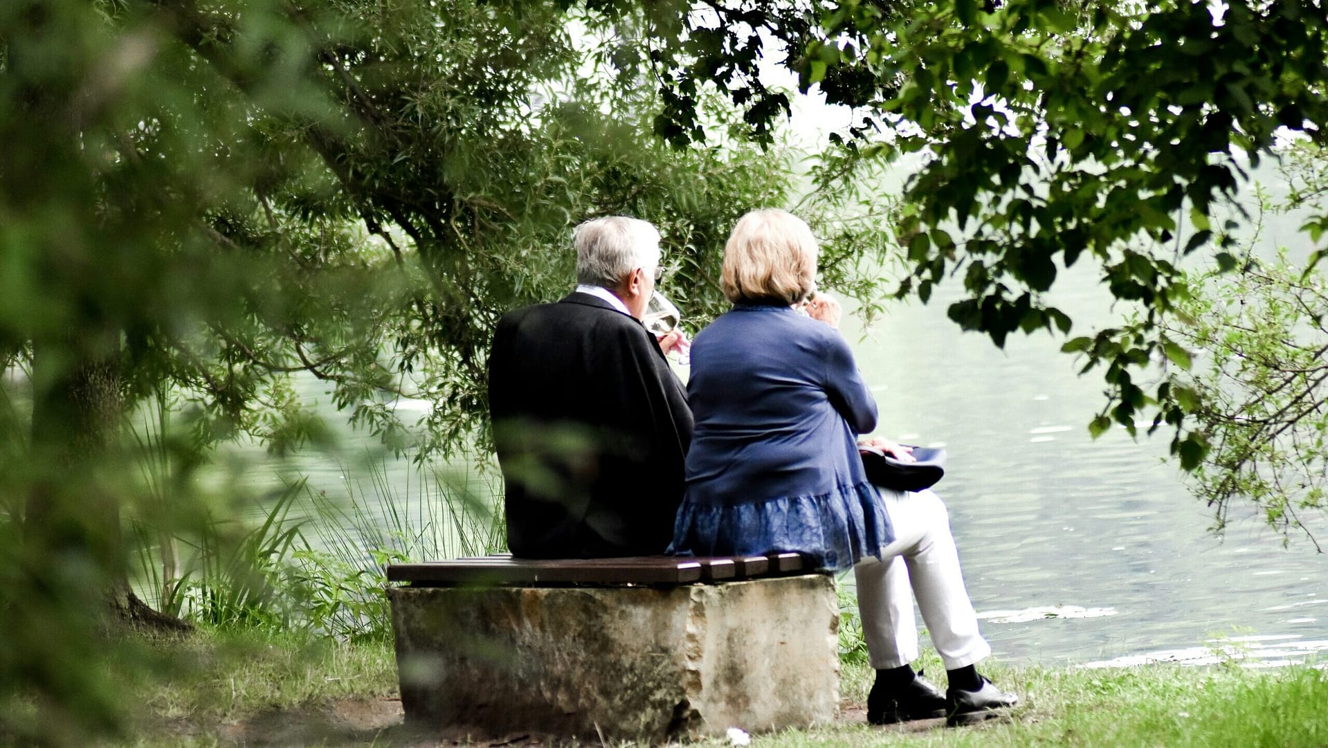 Older couple sitting by a lake, discussing estate plans after a family loss in Indiana